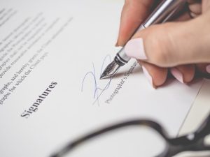 generic DIY will, image of fingers with nail polish signing a document