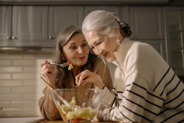 aging in place, Medicaid waiver, image of two senior women laughing in kitchen