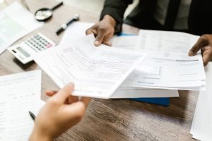 How Is an Inheritance Taxed in New Jersey, image of a tax form changing hands across a desk