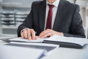 life insurance in your estate plan, image of the torso of a man in a suit working at a desk
